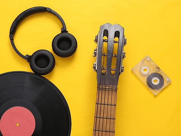 disco cascos guitarra y cassette sobre fondo blanco